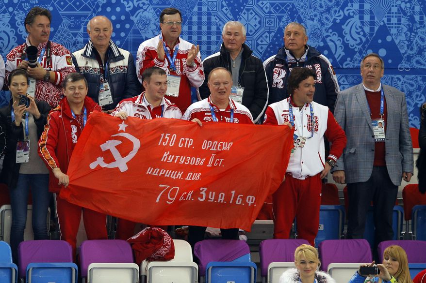 Russian Communist Party leader Gennady Zyuganov, bottom row center, holds the Soviet Banner of Victory with others during a flower ceremony for the short track speedskating competition at the Iceberg Skating Palace during the 2014 Winter Olympics, Friday, Feb. 21, 2014, in Sochi, Russia. The banner is a replica of the flag raised by Soviet soldiers in Berlin in 1945, in victory over Nazi Germany. (AP Photo/Vadim Ghirda)