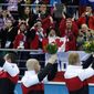 E.J. Harnden, left, Ryan Fry, center, and Brad Jacobs, acknowledge the fans during the flower ceremony after defeating Britain in the men&#39;s curling gold medal game  at the 2014 Winter Olympics, Friday, Feb. 21, 2014, in Sochi, Russia. (AP Photo/Robert F. Bukaty)