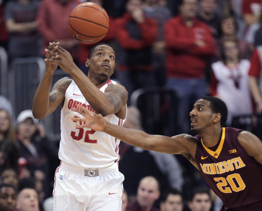 Minnesota's Austin Hollins, right, tips the ball away from Ohio State's Lenzelle Smith during the first half of an NCAA college basketball game Saturday, Feb. 22, 2014, in Columbus, Ohio. (AP Photo/Jay LaPrete)