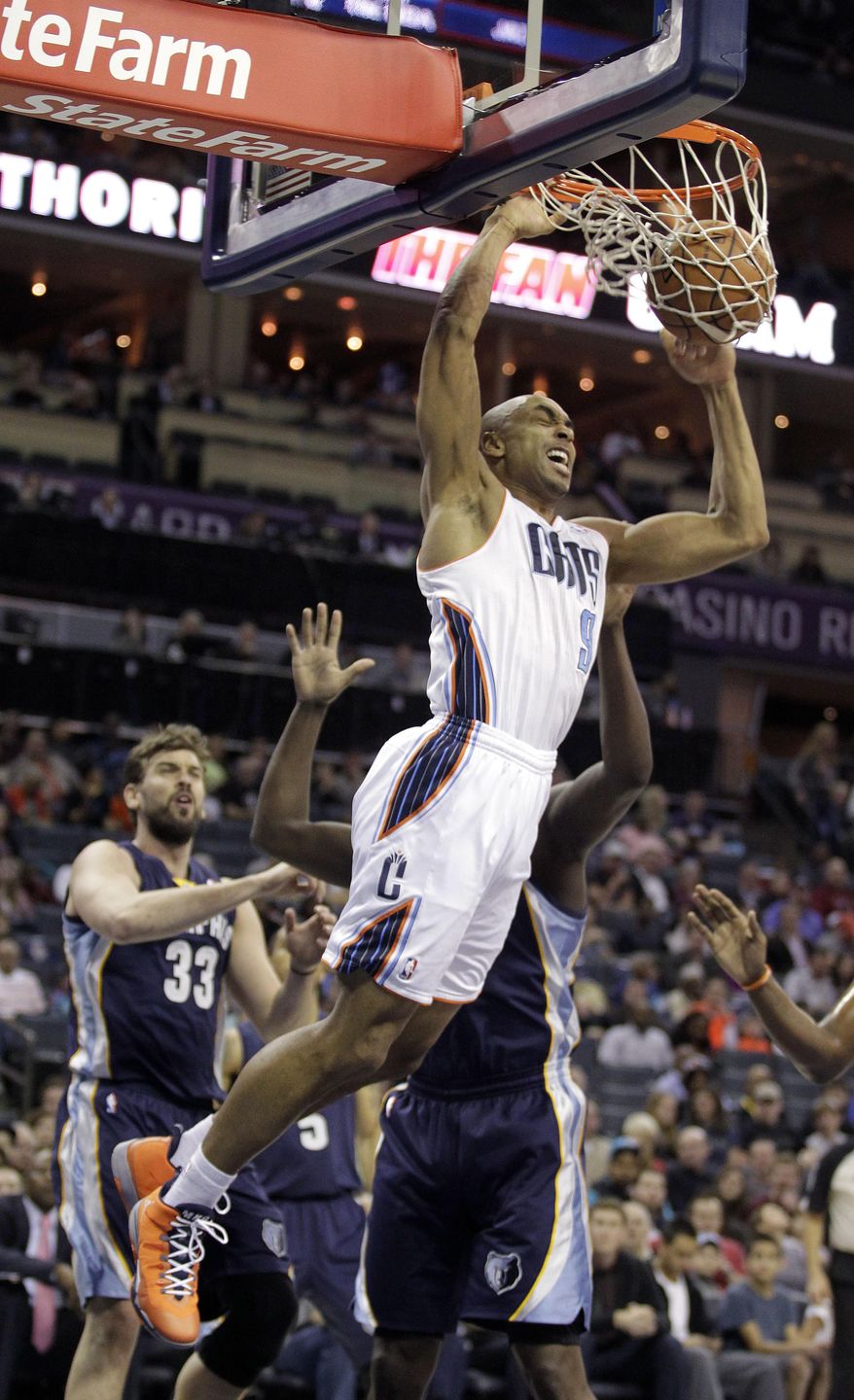The Charlotte Bobcats' Gerald Henderson (9) dunks over the Memphis Grizzlies' Marc Gasol (33) and Zach Randolph during the first half of an NBA basketball game in Charlotte, N.C., Saturday, Feb. 22, 2014. (AP Photo/Bob Leverone)