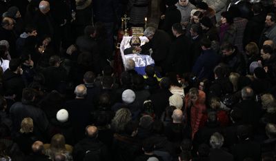 An open casket with the body of Bogdan Solchunuk, 28, lays in the centre of St. Paul and Peter church, during his funeral service in Lviv, western Ukraine, Saturday, Feb. 22, 2014. Church services were held Saturday in the pro-opposition stronghold of Lviv in the west of Ukraine for the locals who were killed in Kiev during the past week. Lviv activists say 19 of their people were killed in the violence at Maidan. (AP Photo/Darko Vojinovic)