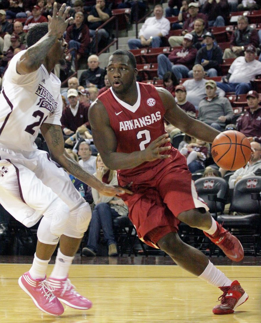 Arkansas' Alandise Harris (2) drives past Mississippi State's Roquez Johnson, left, during the first half of an NCAA college basketball game in Starkville, Miss., Saturday, Feb. 22, 2014. (AP Photo/Jim Lytle)