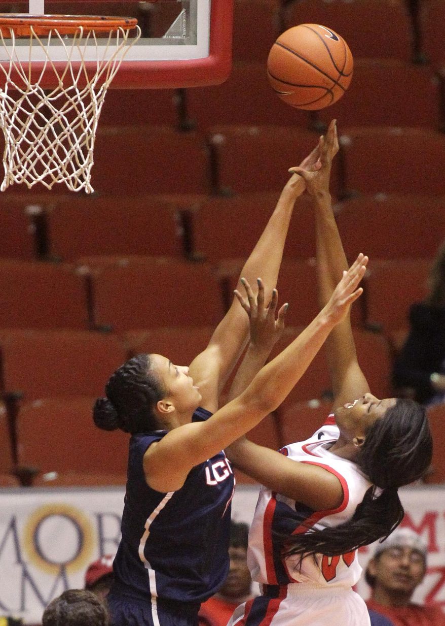 Houston center Mae Woods, right, takes a shot over Connecticut center Kiah Stokes during the second half of an NCAA women's basketball game, Saturday, Feb. 22, 2014, in Houston. (AP Photo/Patric Schneider)