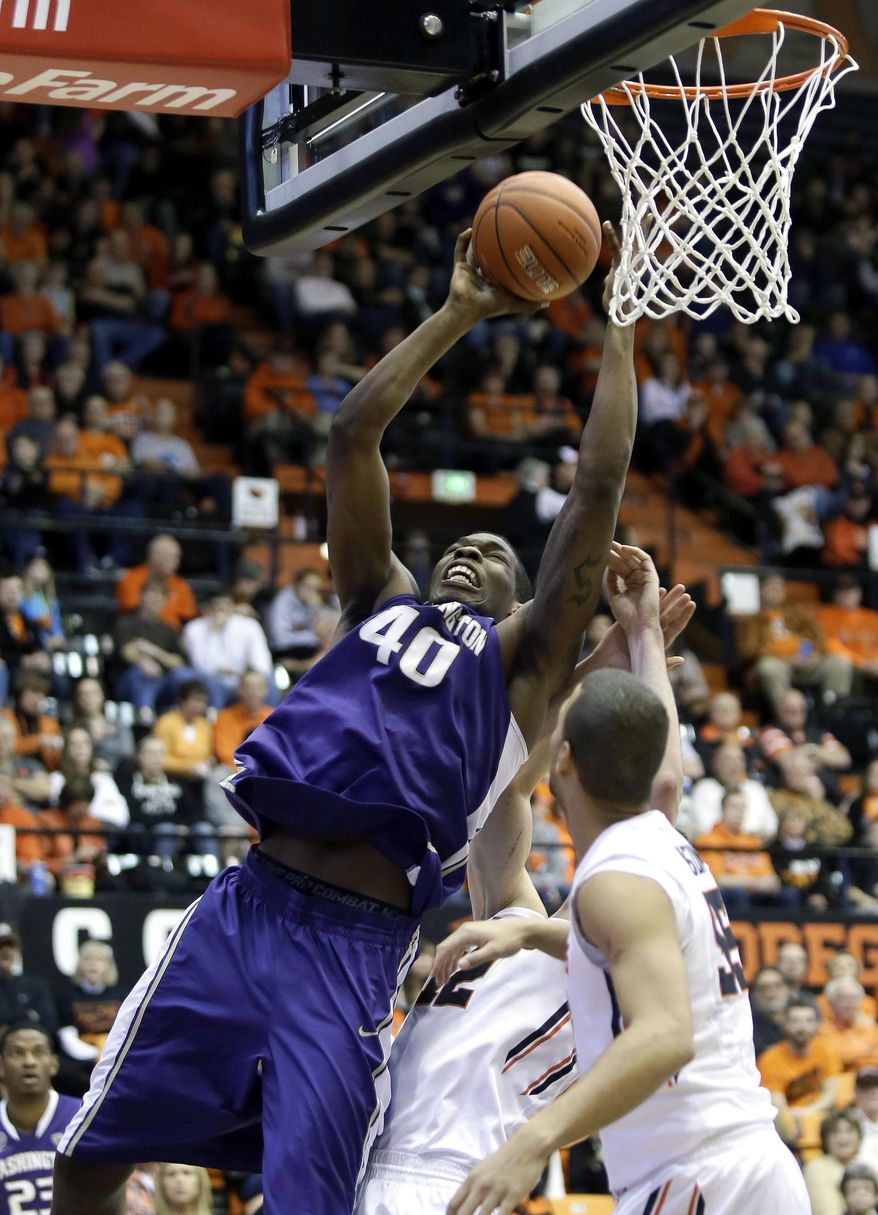 Washington forward Shawn Kemp, Jr., left, shoot against Oregon State's Roberton Nelson, right, and Angus Brandt during the first half of an NCAA basketball game in Corvallis, Ore., Saturday, Feb. 22, 2014. (AP Photo/Don Ryan)