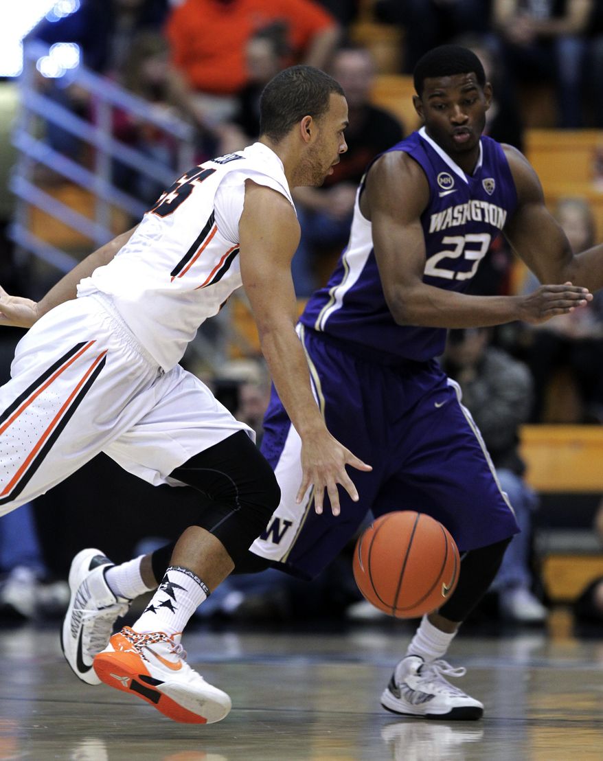 Oregon State guard Roberto Nelson, left, drives on Washington guard C.J. Wilcox during the first half of an NCAA basketball game in Corvallis, Ore., Saturday, Feb. 22, 2014.(AP Photo/Don Ryan)