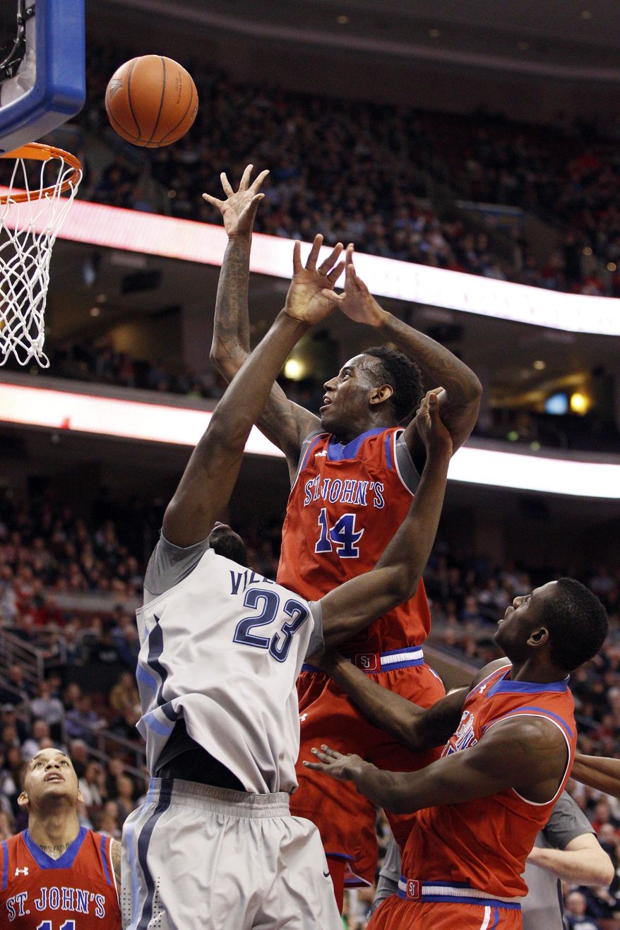 St. John's Jakarr Sampson, center, puts up the shot over Villanova's Daniel Ochefu, left, with St. John's Sir'Dominic Pointer along side them during the first half of an NCAA college basketball game, Saturday, Feb. 22, 2014, in Philadelphia. (AP Photo/Chris Szagola)
