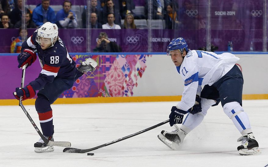 USA forward Patrick Kane breaks his stick while taking a shot on goal as Finland forward Leo Komarov defends during the second period of the men's bronze medal ice hockey game at the 2014 Winter Olympics, Saturday, Feb. 22, 2014, in Sochi, Russia. Komarov was called for slashing on the play and the USA was awarded a penalty shot. (AP Photo/Petr David Josek)