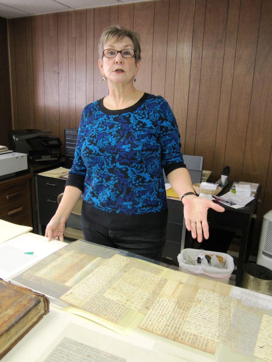 ADVANCE FOR MONDAY FEB. 24 AND THEREAFTER - This Sunday Feb. 16, 2014 photo shows Sarah Latham, president of the Danville Historical Society, as she looks over a recently-donated collection of letters written by a Civil War soldier from Pittsylvania County to his wife, at the museum in Danville, Va. The elaborate script and often-misspelled words of Pvt. Joseph Payne’s letters home to his wife have made transcribing them a challenge. (AP Photo/The Register & Bee, Denice Thibodeau)