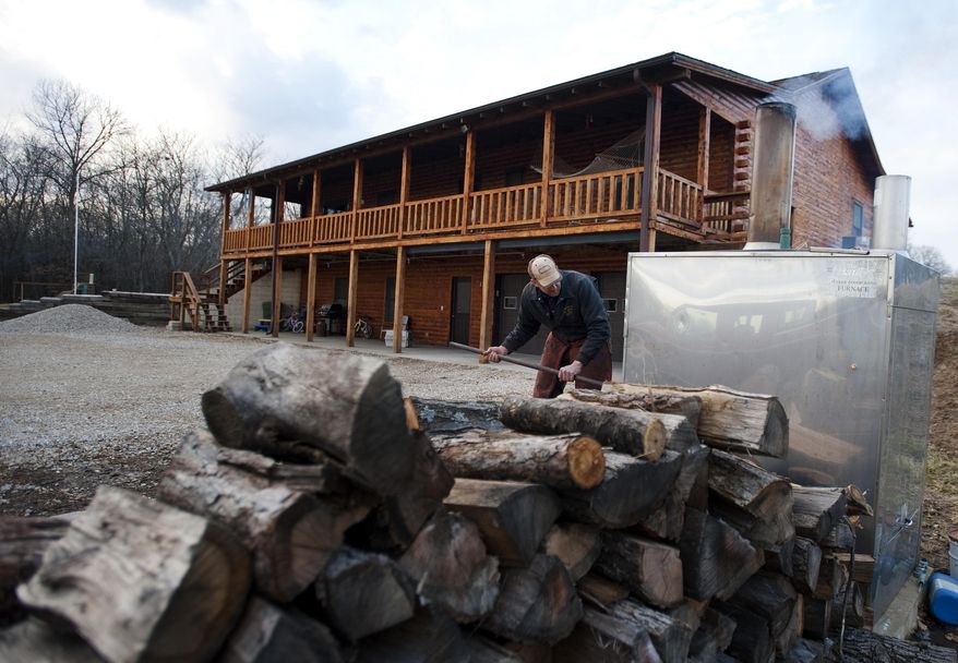Darwin Woods stokes the fire in the wood burning stove that he uses to heat both his home and water Friday, Feb. 21, 2014, at his home near Clark, Mo. Proposed regulations from the U.S. Environmental Protection Agency would significantly reduce the amount of particle pollution allowed from the smokestacks of new residential wood-powered heaters. The proposed regulations have sparked a backlash from some rural residents, lawmakers and manufacturers who fear it could close the damper on one of the oldest ways of warming homes on cold winter days. (AP Photo/L.G. Patterson)