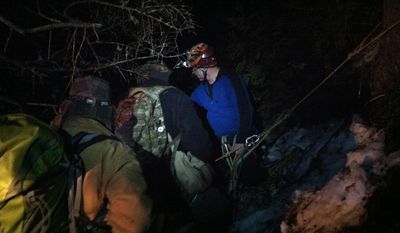 This photo provided by the Maine Warden Service, shows four professional climbers lowering a group of three Boy Scouts and two of their adult leaders down from the side of Black Cap Mountain in Eddington, Maine, early Sunday, Feb. 23, 2014. (AP Photo/Maine Warden Service)