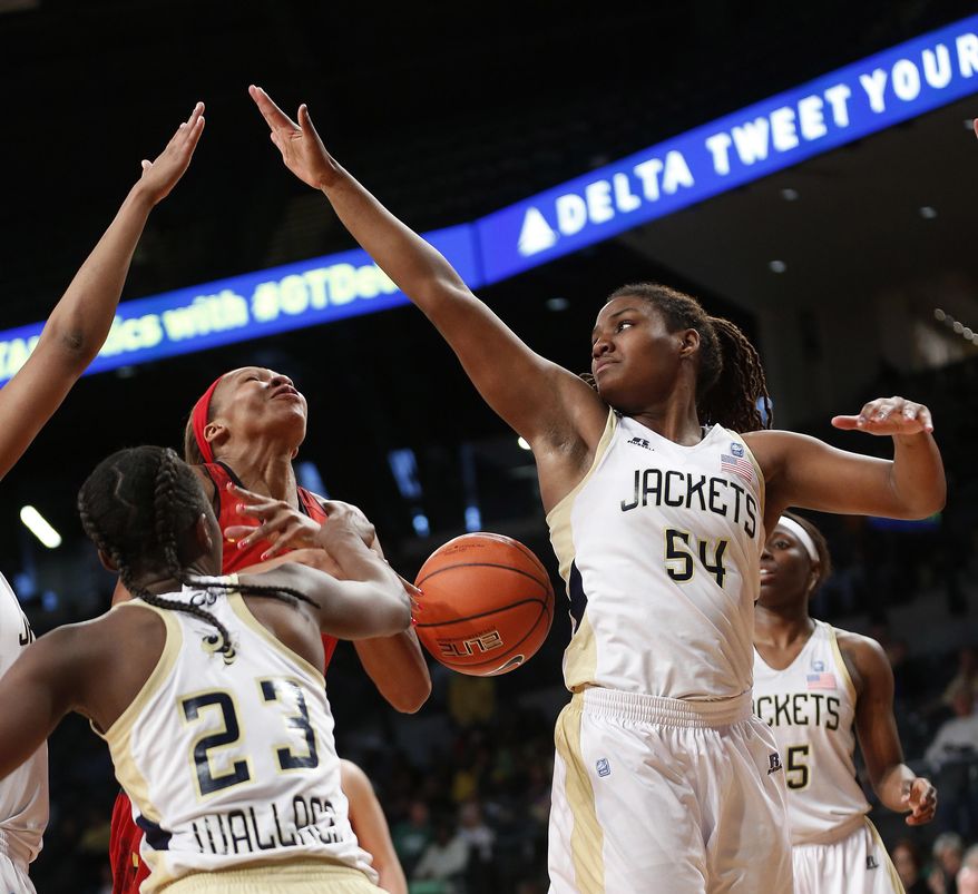 Maryland center Alicia DeVaughn (13) looses the ball as she tries to drive between Georgia Tech guard Sydney Wallace (23) and Georgia Tech forward Roddreka Rogers (54)in the second half of an NCAA college basketball game, Sunday, Feb. 23, 2014, in Atlanta. (AP Photo/John Bazemore)