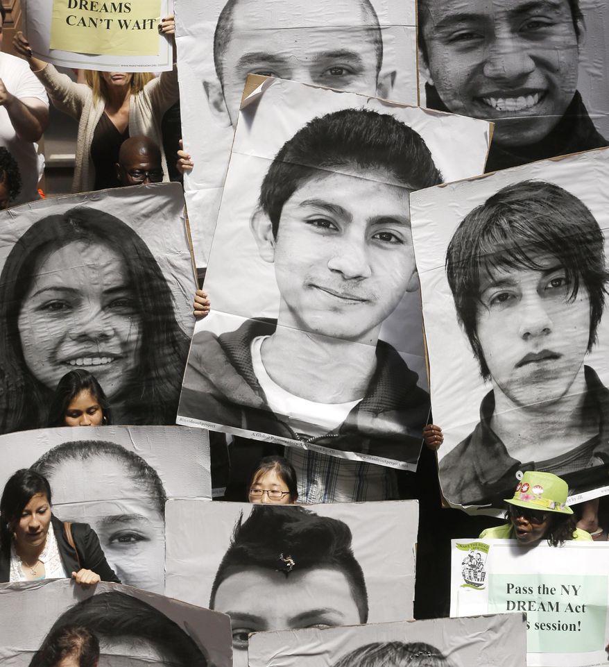 FILE--In this May 21, 2013 file photo, supporters of the New York DREAM Act hold photos of undocumented students who are not eligible for college tuition assistance during a rally at the Capitol in Albany, N.Y. Supporters of the bill that would give undocumented immigrant students in New York access to state tuition assistance weren’t giving it much of a chance in this election year, planning instead for a push in 2015. But unforeseen support from New York City Mayor Bill de Blasio and more Democratic lawmakers has breathed new life into the state’s proposed “Dream Act” and given hope to immigrant students who would otherwise be shut out of state financial aid. (AP Photo/Mike Groll, File)