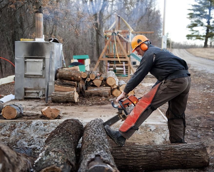 Darwin Woods cuts wood for his wood burning stove that he uses to heat his workshop Friday, Feb. 21, 2014, at his home near Clark, Mo. Woods says he considers the proposed EPA rule for new wood-stoves the latest example of an agency run amok. Proposed regulations from the U.S. Environmental Protection Agency that would significantly reduce the amount of particle pollution allowed from the smokestacks of new residential wood-powered heaters have sparked a backlash from some rural residents, lawmakers and manufacturers who fear it could close the damper on one of the oldest ways of warming homes on cold winter days. (AP Photo/L.G. Patterson)