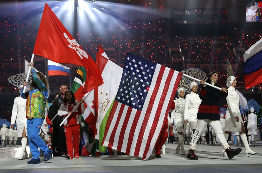 United States' Julie Chu, right, carries the flag during the closing ceremony of the 2014 Winter Olympics, Sunday, Feb. 23, 2014, in Sochi, Russia. (AP Photo/Darron Cummings)