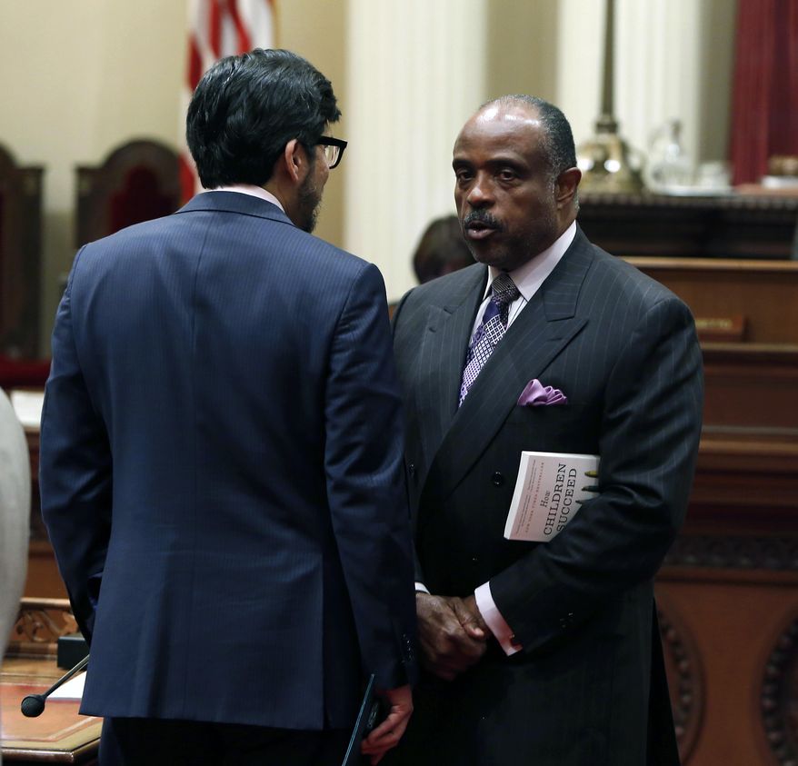 State Sen. Roderick Wright, D-Inglewood, right, talks with Sen. Kevin de Leon, D-Los Angeles, during the Senate session at the Capitol in Sacramento, Calif., Monday Feb. 24, 2014.  After a closed door meeting Monday, Democratic lawmakers said they will give state Sen. Ron Calderon, D-Montebello, who faces federal corruption charges, one week to resign or take an indefinite leave of absence. If he does not, the Senate will move to suspend him. Calderon pleaded not guilty Monday to federal corruption charges involving bribes, kickbacks and fraud. (AP Photo/Rich Pedroncelli)