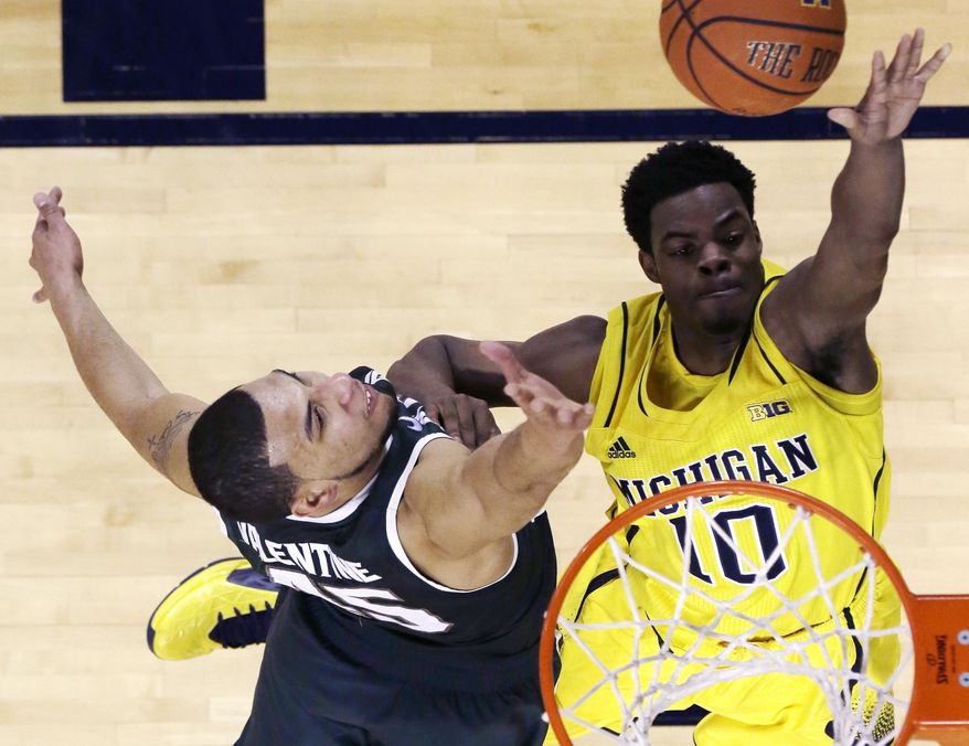 Michigan guard Derrick Walton Jr. (10) shoots over Michigan State guard Denzel Valentine (45) during the second half of an NCAA college basketball game in Ann Arbor, Mich., Sunday, Feb. 23, 2014. (AP Photo/Carlos Osorio)