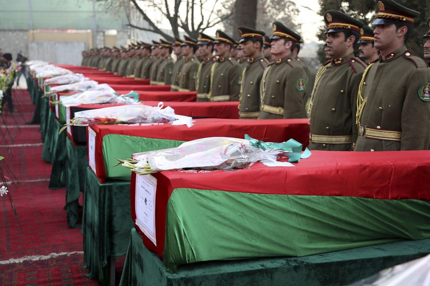 Members of the Honor Guard stand at attention near the caskets of victims of Afghan national army soldiers during a funeral ceremony in Kabul, Afghanistan, Monday, Feb. 24, 2014. Hundreds of heavily armed Taliban insurgents attacked the checkpoint on Sunday, officials said, killing 21 soldiers in the deadliest single incident for the Afghan army in at least a year. (AP Photo/Rahmat Gul)