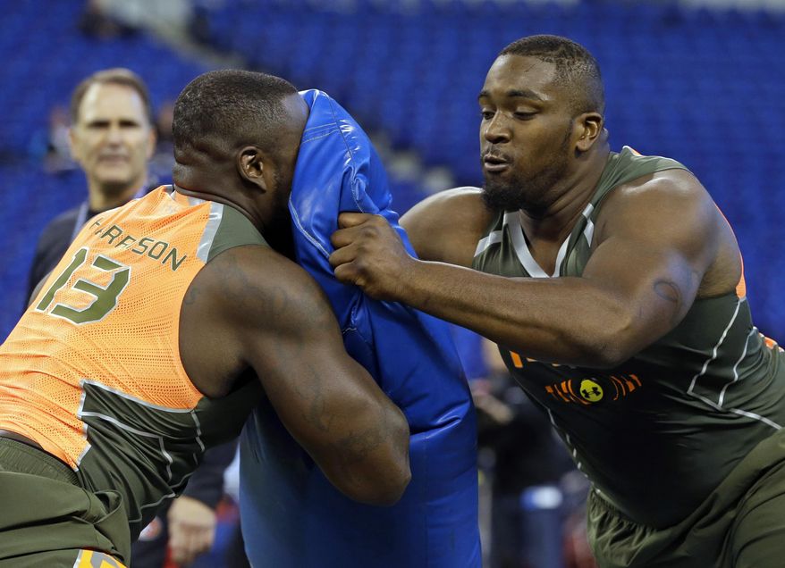 Miami offensive lineman Seantrel Henderson, right, blocks Florida offensive lineman Jonotthan Harrison during a drill at the NFL football scouting combine in Indianapolis, Saturday, Feb. 22, 2014. (AP Photo/Michael Conroy)