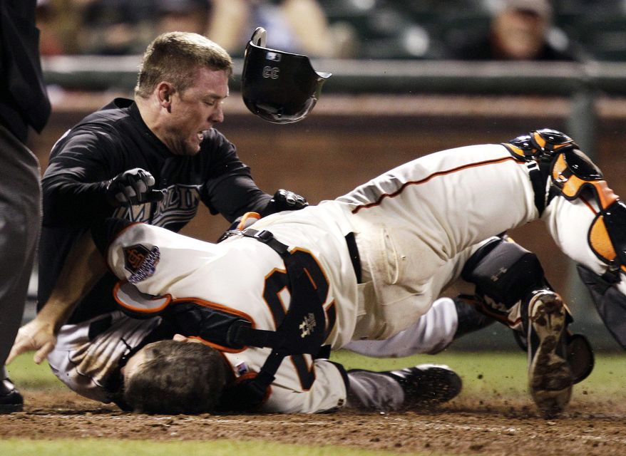 FILE - In this May 25, 2011 file photo, Florida Marlins' Scott Cousins, top, collides with San Francisco Giants catcher Buster Posey (28) on a fly ball from Emilio Bonifacio during the 12th inning of a baseball game in San Francisco. Cousins was safe for the go ahead run. A new rule, 7.13, was adopted by MLB and the players' association on a one-year experimental basis, the sides said Monday, Feb. 24, 2014. The umpire crew chief can use the new video-review system to determine whether the rule was violated. (AP Photo/Marcio Jose Sanchez, File)