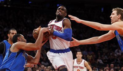 New York Knicks' Tim Hardaway, Jr., center, drives against Dallas Mavericks' Devin Harris, left, and Dirk Nowitzki during the first half of an NBA basketball game, Monday, Feb. 24, 2014, in New York. (AP Photo/Jason DeCrow)