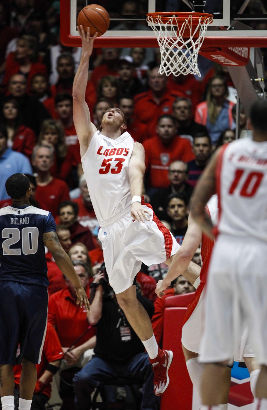 New Mexico's Alex Kirk puts up a shot as Utah State's TeNale Roland (20) looks on during the first half of an NCAA college basketball game, Tuesday, Feb.25, 2014 in Albuquerque, N.M. (AP Photo/Craig Fritz)