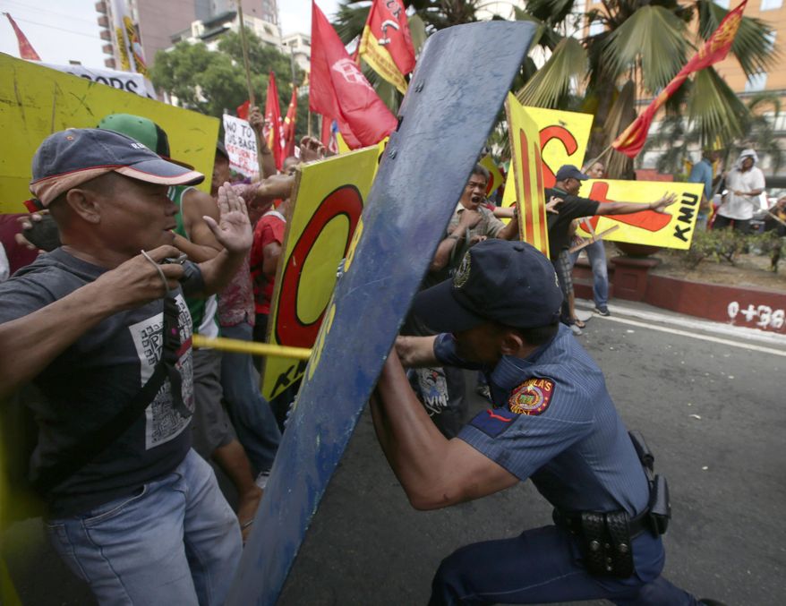 Demonstrators clash with police on their way closer to U.S. Embassy in Manila, Philippines, Tuesday, Feb. 25, 2014 to protest the forthcoming visit of U.S. President Barack Obama. The protesters were also calling for the pullout of U.S. troops in the country under the Visiting Forces Agreement (VFA). (AP Photo/Bullit Marquez)