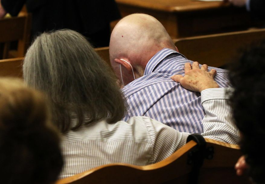 Patricia Butterfield comforts her husband Paul Butterfield, right, as Mason County Prosecutor Paul Spaniola makes his closing remarks during the sixth day of the murder trial for Eric Knysz in Mason County's 51st Circuit Court Judge Richard I. Cooper in Ludington, Mich., on Tuesday, Feb. 25, 2014. Knysz is charged in the September 2013 shooting death of their son, Michigan State Police Trooper Paul Butterfield II during a traffic stop in rural Mason County. (AP Photo/The Muskegon Chronicle, Ken Stevens) ALL LOCAL TV OUT; LOCAL TV INTERNET OUT.