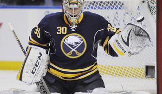 Buffalo Sabres goaltender Ryan Miller reaches out with his glove to stop the puck during the second period of an NHL hockey game against the Carolina Hurricanes in Buffalo, N.Y., Tuesday, Feb. 25, 2014. Buffalo won 3-2. (AP Photo/Gary Wiepert)