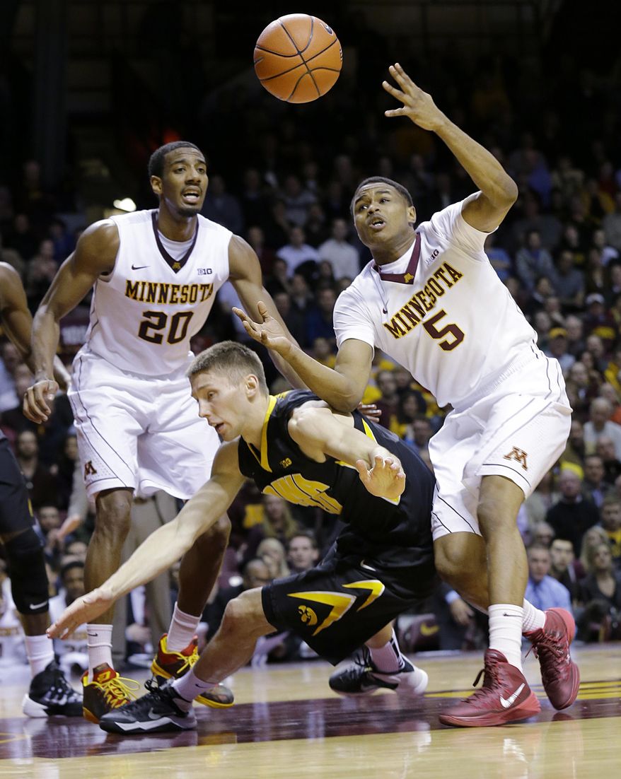 Minnesota guard Daquein McNeil (5) loses control of the ball as he collides with Iowa forward Jarrod Uthoff, center, in front of Minnesota guard Austin Hollins (20) during the first half of an NCAA college basketball game in Minneapolis, Tuesday, Feb. 25, 2014. (AP Photo/Ann Heisenfelt)