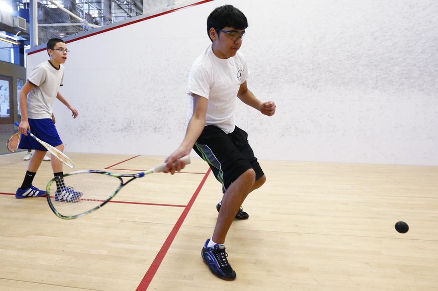 In this Feb. 11, 2014, Klever Rivas, 13, right, and Domingo Tejada, 13, play squash at the Lenfest Center, in Philadelphia. The rough-and-tumble Hunting Park section of Philadelphia is an unusual location for professional squash courts. But it's the perfect place for SquashSmarts, a nonprofit dedicated to keeping inner-city kids physically and academically fit through squash instruction and mentoring. (AP Photo/Matt Rourke)