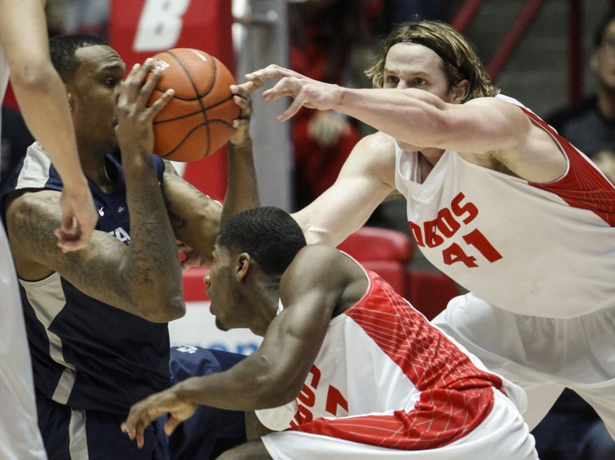 Utah State's Jarred Shaw, left, tries to hold onto the ball while New Mexico's Deshawn Delaney, center, and Cameron Bairstow, right, make a play for it during the first half of an NCAA college basketball game, Tuesday, Feb. 25, 2014 in Albuquerque, N.M. (AP Photo/Craig Fritz)