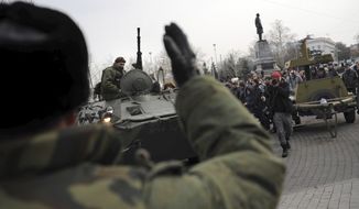 A Russian Army officer, back to camera, helps an armored personnel carrier drive on a street in Sevastopol, Ukraine&#39;s Black Sea Port that hosts a major Russian navy base Tuesday, Feb. 25, 2014. Tensions were building up in the Crimea, where ethnic Russians who make the majority of the local population are deeply suspicious of the new Ukrainian authorities who replaced fugitive Russia-backed President Viktor Yanukovych. (AP Photo/Andrew Lubimov)