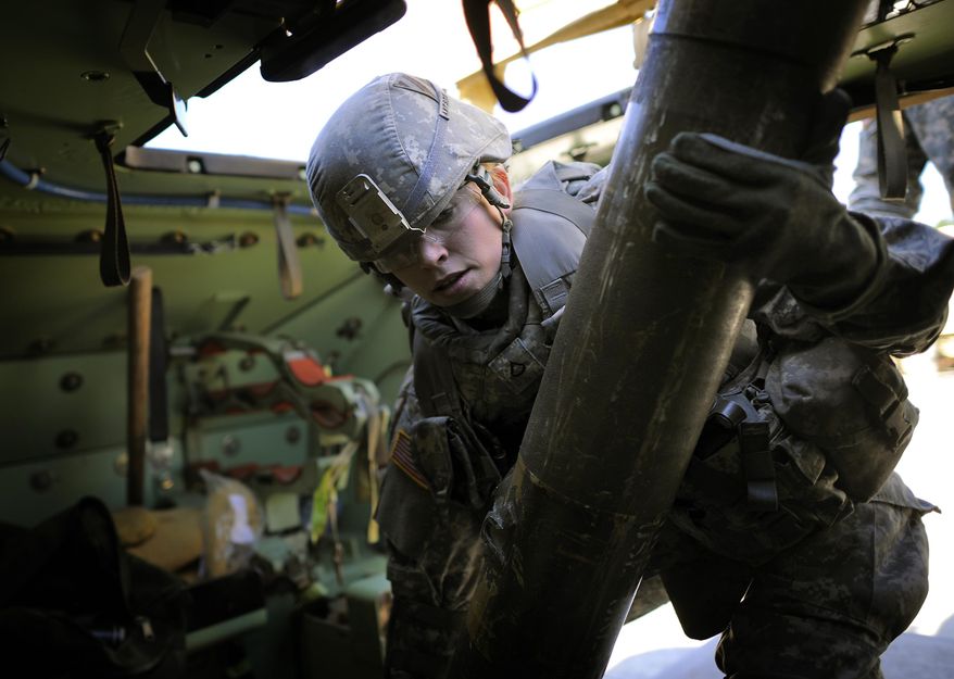 U.S. Army PFC Amy Alexanders lifts a 65-pound T.O.W. missile through a hatch into the launcher of a Bradley Fighting Vehicle during a physical demands study, Tuesday, Feb. 25, 2014, in Ft. Stewart, Ga. The Army is conducting a study that will determine how all soldiers, including women, for the first time, will be deemed fit to join its fighting units from infantry platoons to tank crews. (AP Photo/Stephen B. Morton)
