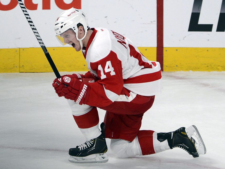 Detroit Red Wings center Gustav Nyquist (14) celebrates his game-winning goal in overtime in a 2-1 victory over the Montreal Canadiens in an NHL hockey game Wednesday, Feb. 26, 2014, in Montreal. (AP Photo/The Canadian Press, Ryan Remiorz)