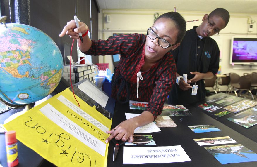 FOR RELEASE SUNDAY, MARCH 2, 2014, AT 12:01 A.M. CST. - In this photo from Feb. 20, 2014, Chisom Anyanwu, 15, left, and Blake Gomez, 14, right, work on a project about Laos at the Energy Institute High School in Houston. It is the first high school in the nation to focus on careers in oil, gas and other energy sources and technologies. (AP Photo/Houston Chronicle, Melissa Phillip)