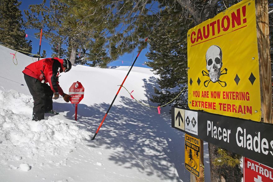 Ski patroller Adam Clifton adjusts an avalanche danger flip sign to reflect the day's relative risk, on Corona Bowl, known for its extreme skiing, at Eldora Mountain Resort, near Nederland, Colo., Wednesday, Feb. 26, 2014. Lots of new snow and strong winds in the past month have fueled dangerous conditions from the Cascades to the Rockies, prompting forecasters to issue warnings of considerable or high avalanche dangers for many areas outside of established ski areas. (AP Photo/Brennan Linsley)