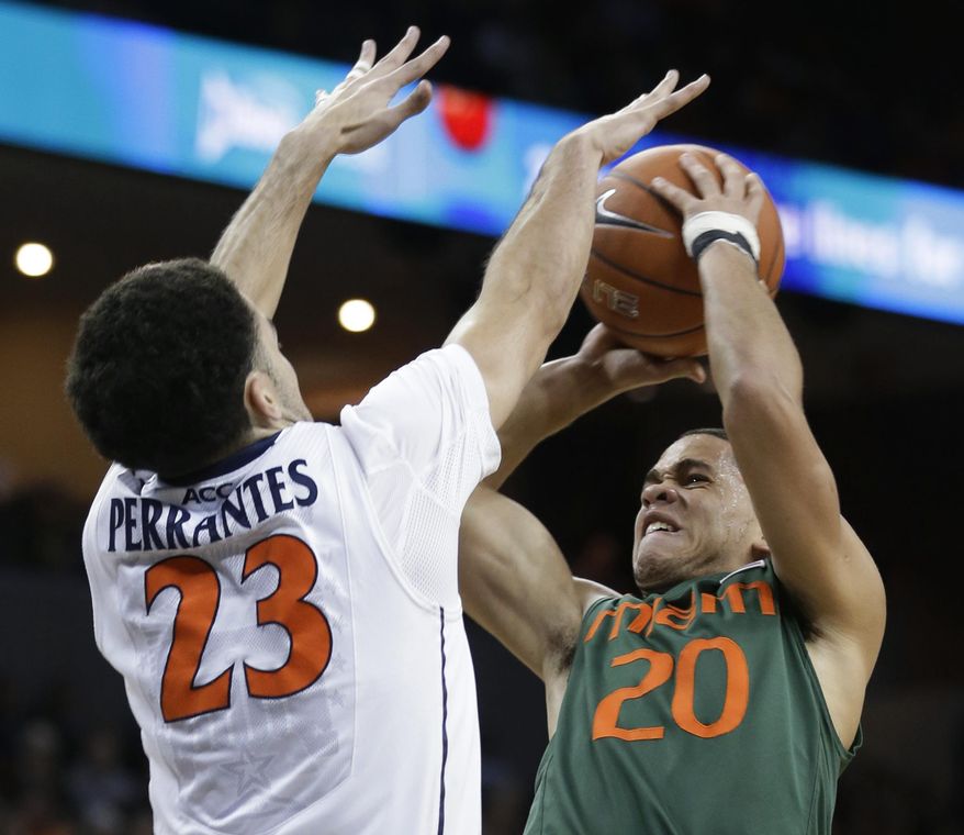 Virginia guard London Perrantes (23) tries to block the shot of Miami guard Manu Lecomte (20) during the first half of an NCAA college basketball game in Charlottesville, Va., Wednesday, Feb. 26, 2014. (AP Photo/Steve Helber)