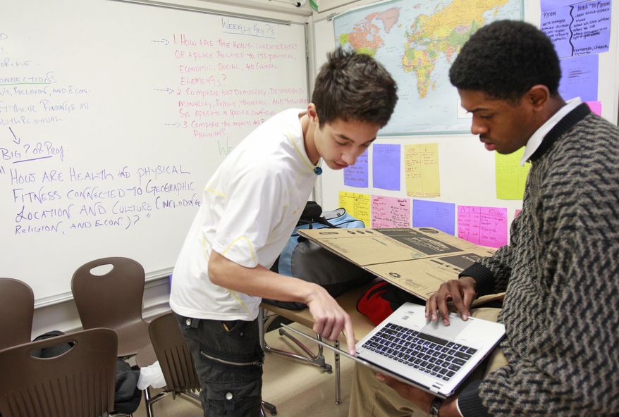FOR RELEASE SUNDAY, MARCH 2, 2014, AT 12:01 A.M. CST. In this photo from Feb. 20, 2014, freshmen students Caio Carugati, left, and David Miller, right, both 15, work on a project about Kuwait at the Energy Institute High School in Houston. It is the first high school in the nation to focus on careers in oil, gas and other energy sources and technologies. (AP Photo/Houston Chronicle, Melissa Phillip)