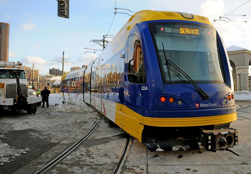 CORRECTS 12TH AVENUE TO 12TH STREET - Metro Transit crews work to get a light rail train back on track after it derailed while travelling north on the Green Line at Cedar Street and 12th Street in downtown St. Paul, Minn. on Wednesday, Feb. 26, 2014. (AP Photo/Pioneer Press, John Autey) MINNEAPOLIS STAR TRIBUNE OUT