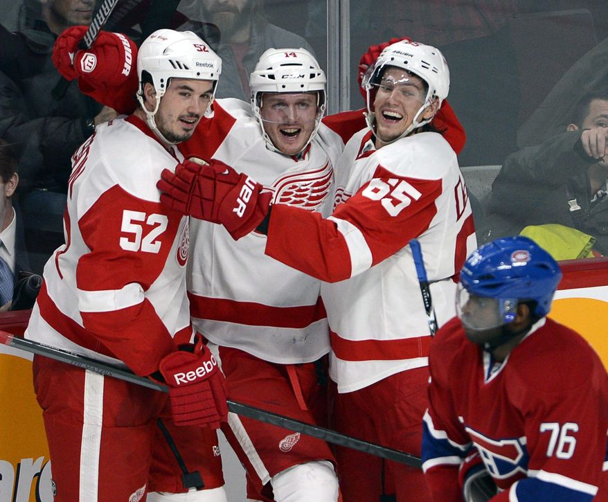 Detroit Red Wings center Gustav Nyquist (14) celebrates his winning goal with defensemen Jonathan Ericsson (52) and Danny DeKeyser (65) as Montreal Canadiens defenseman P.K. Subban (76) skates by during overtime in an NHL hockey game Wednesday, Feb. 26, 2014, in Montreal. Detroit won 2-1. (AP Photo/The Canadian Press, Ryan Remiorz)