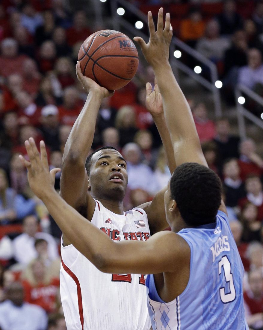 North Carolina's Kennedy Meeks (3) defends while North Carolina State's T.J. Warren shoots during the first half of an NCAA college basketball game in Raleigh, N.C., Wednesday, Feb. 26, 2014. (AP Photo/Gerry Broome)