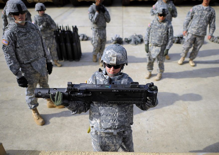 U.S. Army SPC Sheena Mature hoists a 44-pound section of a 50 caliber machine gun onto a M1 A2 Abrams tank during a physical demands study, Tuesday, Feb. 25, 2014, in Ft. Stewart, Ga. The Army is conducting a study that will determine how all soldiers _ including women, for the first time _ will be deemed fit to join its fighting units from infantry platoons to tank crews. (AP Photo/Stephen B. Morton)