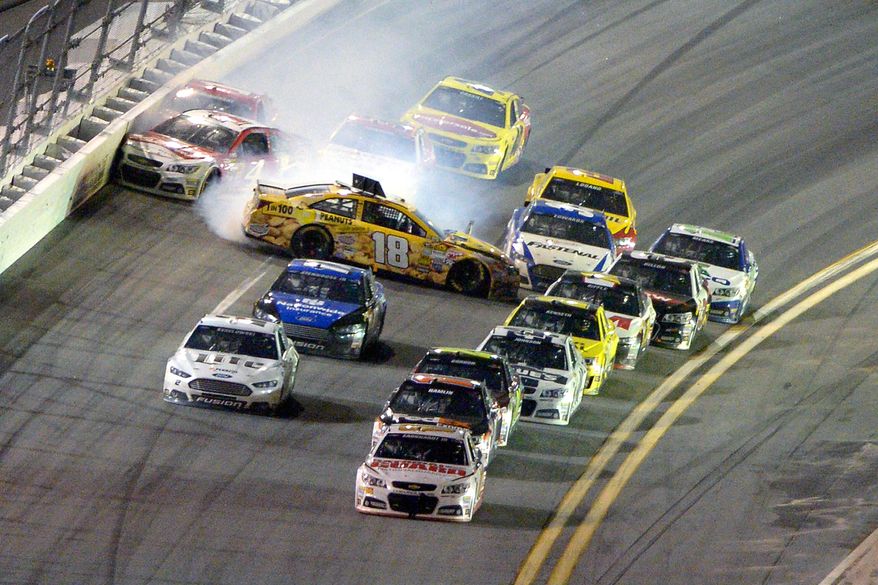 Dale Earnhardt Jr., front, leads the racers to the finish line as Kyle Busch (18) starts a collision coming out of Turn 4 during the NASCAR Daytona 500 auto race at Daytona International Speedway in Daytona Beach, Fla., Sunday, Feb. 23, 2014. (AP Photo/Phelan M. Ebenhack)