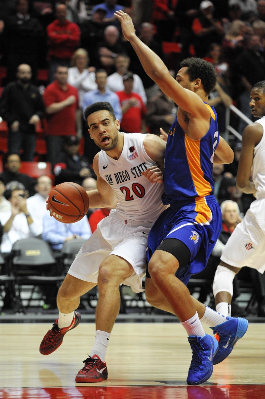 San Diego State's JJ O'Brien (20) tries to drive past San Jose State's Devante Wilson (22) during the first half of an NCAA college basketball game on Tuesday, Feb. 25, 2014, in San Diego. (AP Photo/Denis Poroy)