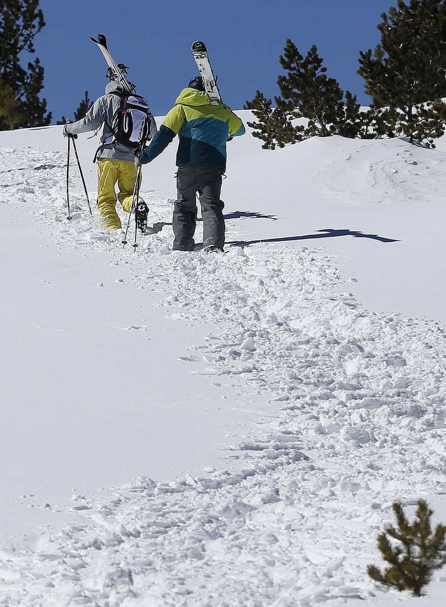 Skiers hike into an avalanche-prone backcountry area of National Forest land adjacent to Corona Bowl, known for its extreme skiing, at Eldora Mountain Resort, near Nederland, Colo., Wednesday, Feb. 26, 2014. Lots of new snow and strong winds in the past month have fueled dangerous conditions from the Cascades to the Rockies, prompting forecasters to issue warnings of considerable or high avalanche dangers for many areas outside of established ski areas. (AP Photo/Brennan Linsley)