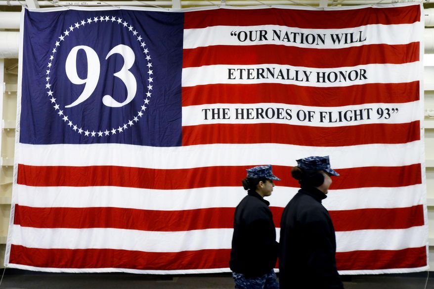 Sailors walk past a flag aboard the USS Somerset Thursday, Feb. 27, 2014, in Philadelphia. The amphibious transport dock scheduled to be commissioned March 1, is the last of three vessels honoring 9/11 victims and first responders. It joins the USS New York and the USS Arlington. The ship is named for the county where Flight 93 crashed after being hijacked on Sept. 11, 2001. (AP Photo/Matt Rourke)