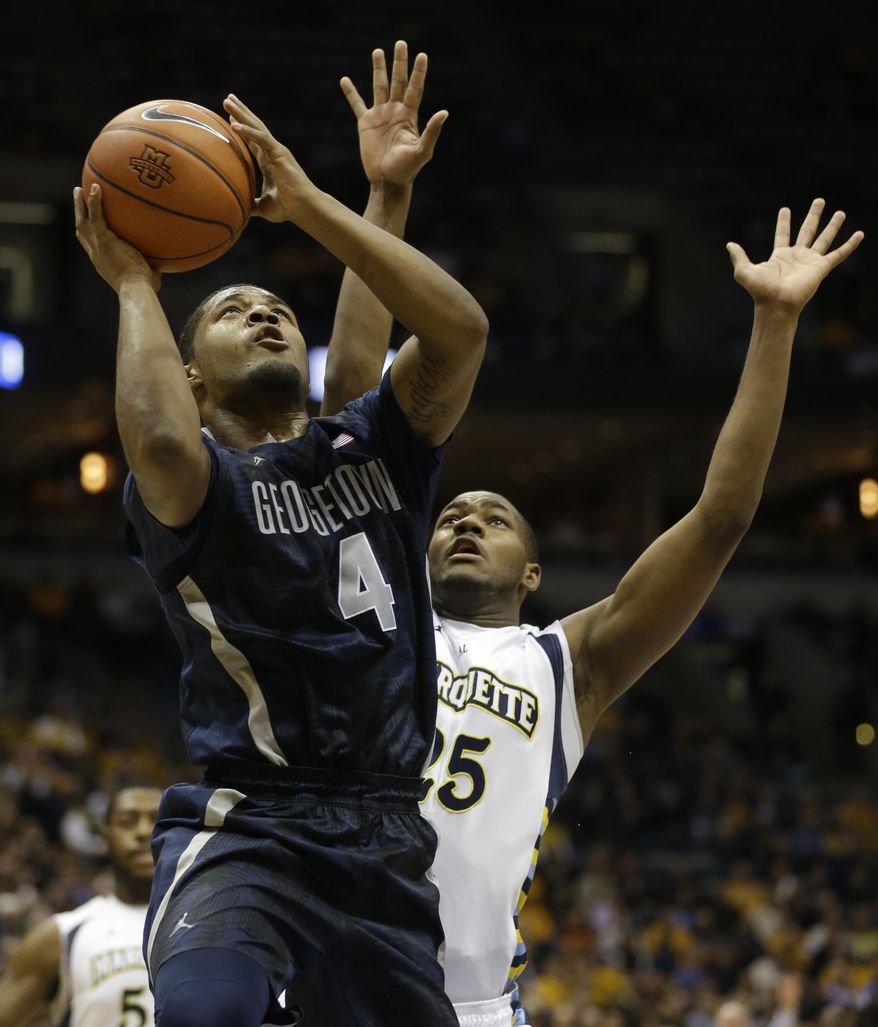 Georgetown's D'Vauntes Smith-Rivera (4) drives against Marquette's Steve Taylor Jr., right, during the second half of an NCAA college basketball game on Thursday, Feb. 27, 2014, in Milwaukee. (AP Photo/Jeffrey Phelps)