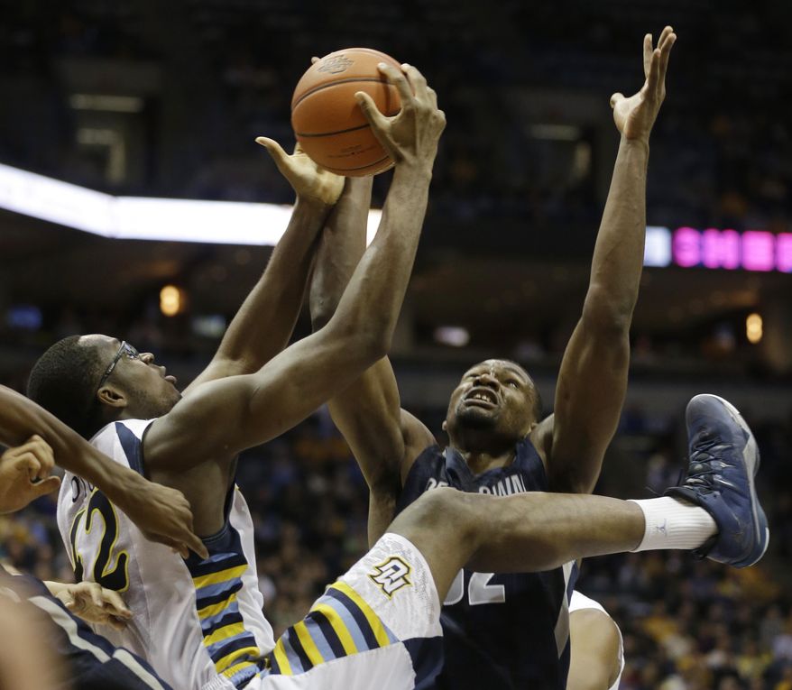 Marquette's Chris Otule, left, and Georgetown's Moses Ayegba reach for a rebound during the first half of an NCAA college basketball game on Thursday, Feb. 27, 2014, in Milwaukee. (AP Photo/Jeffrey Phelps)