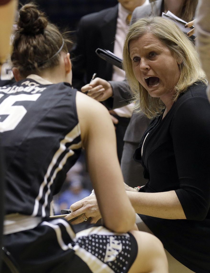 Wake Forest coach Jen Hoover, right, speaks with her team during a timeout in the first half of an NCAA college basketball game against Duke in Durham, N.C., Thursday, Feb. 27, 2014. Duke won 71-56. (AP Photo/Gerry Broome)
