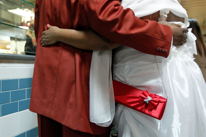 IvoNia Robinson and Mark Ellison II pose for photographs before they and several other couples take their marriage vows on Valentine's Day, at the Reading Terminal Market, Tuesday, Feb. 14, 2012, in Philadelphia. (AP Photo/Matt Rourke)